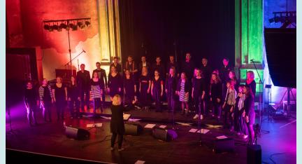 Der Jazzchor Chornfeld auf der Bühne, mit viel buntem Licht