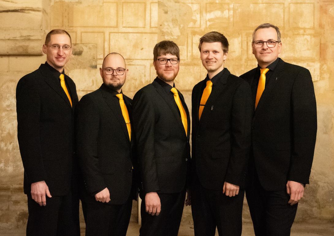 Das Bild zeigt die fünf Mitglieder von Ensemble Felix, alle in schwarzem Anzug mit orange-gelber Krawatte, in der Nikolaikirche Dippoldiswalde.
